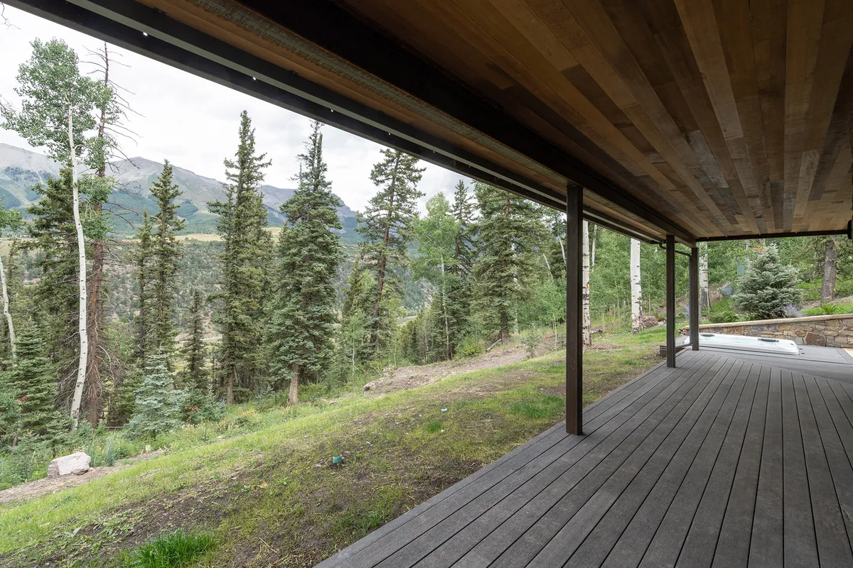 A peaceful wooden deck overlooks the treeline and mountain views, creating an inviting space for outdoor relaxation, gatherings, and enjoying sunsets. The deck’s vantage point connects guests directly to the surrounding natural beauty.